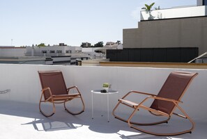 Two rocking chairs on a rooftop terrace with a small table and potted plant. - Casa Dona Irene Sunny Terrace | Room 1 | Early or Late Check-in (Faro)