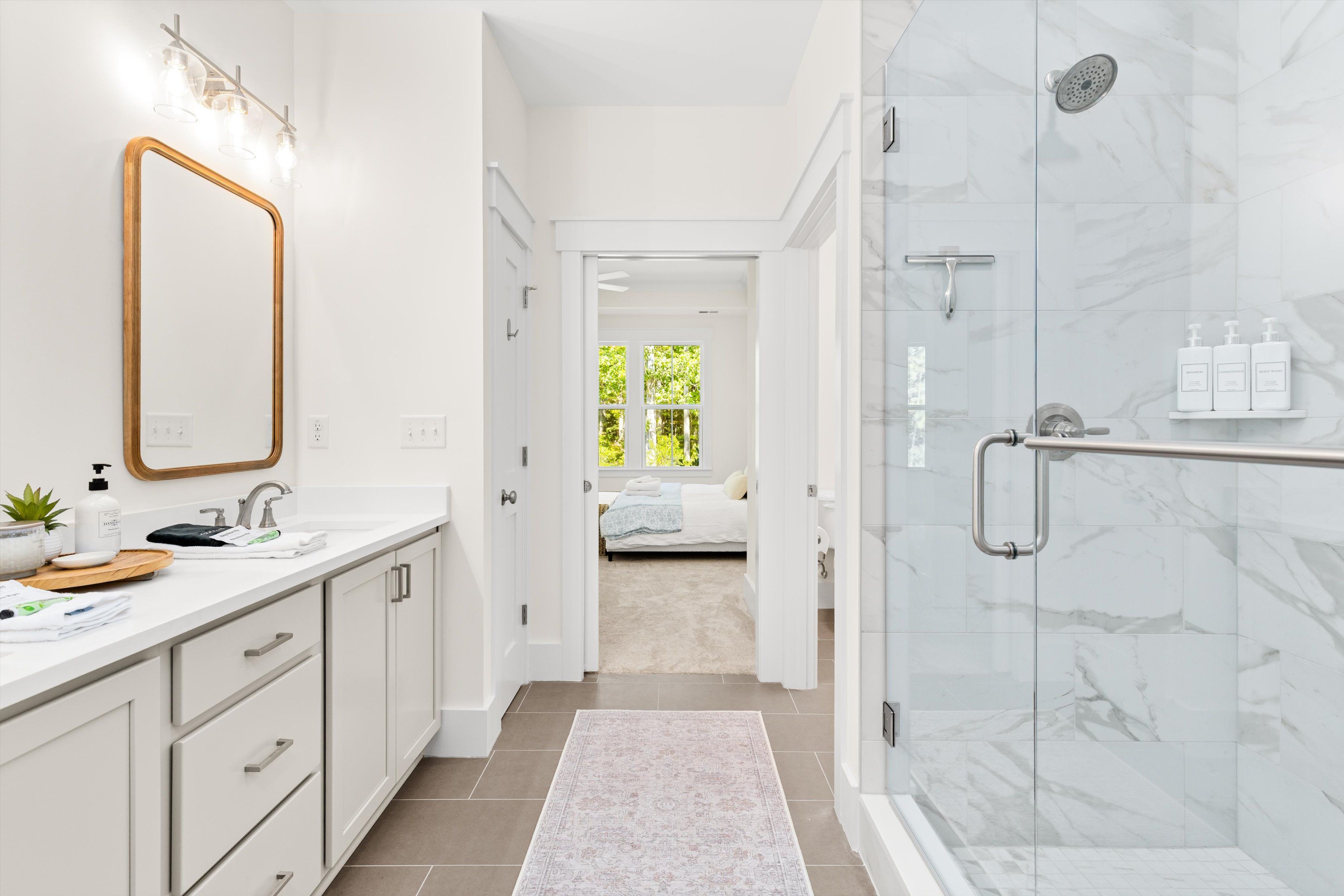 Spa-like bathroom with walk-in marble shower and bright modern vanity