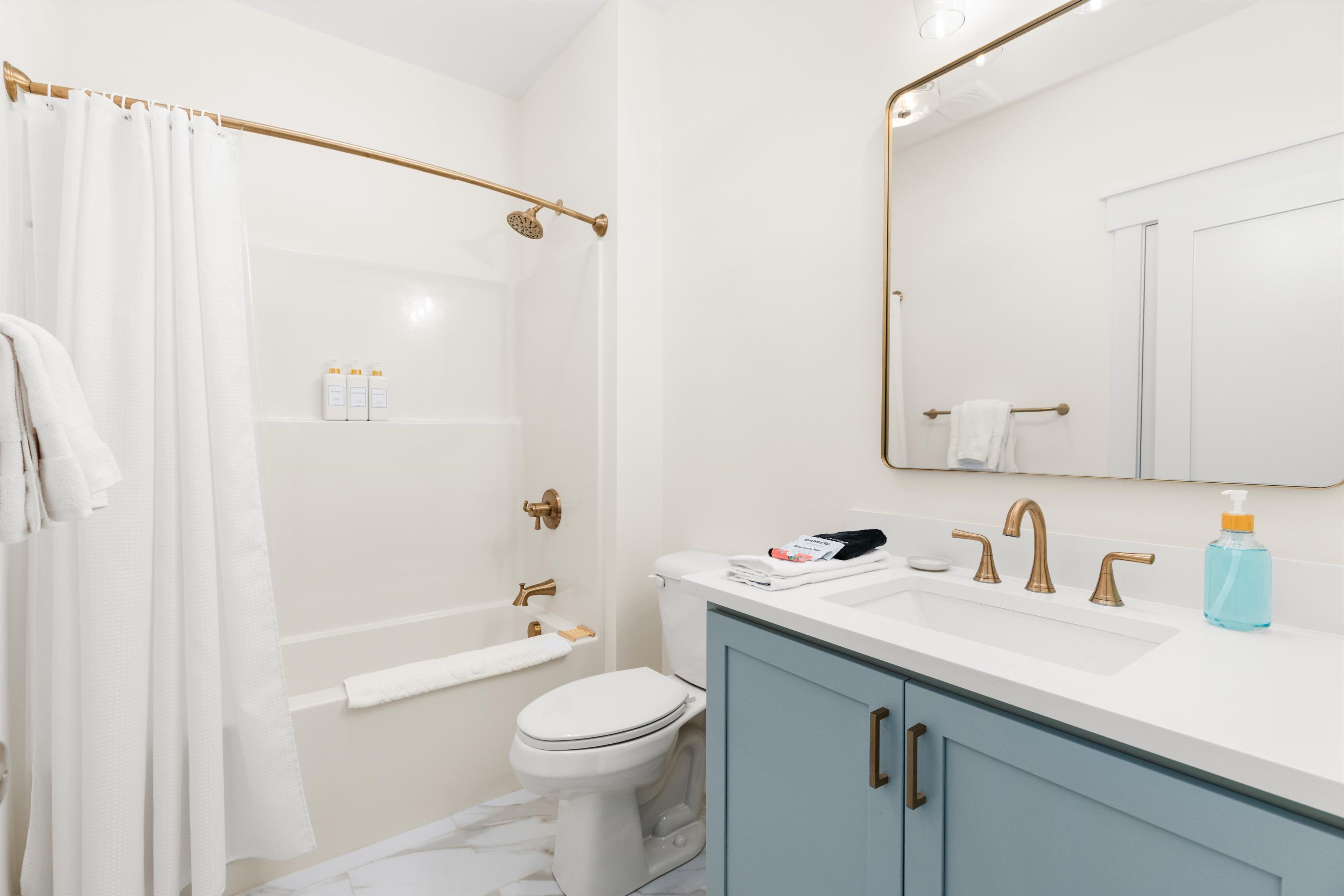Bright modern bathroom with brass finishes and a spacious vanity