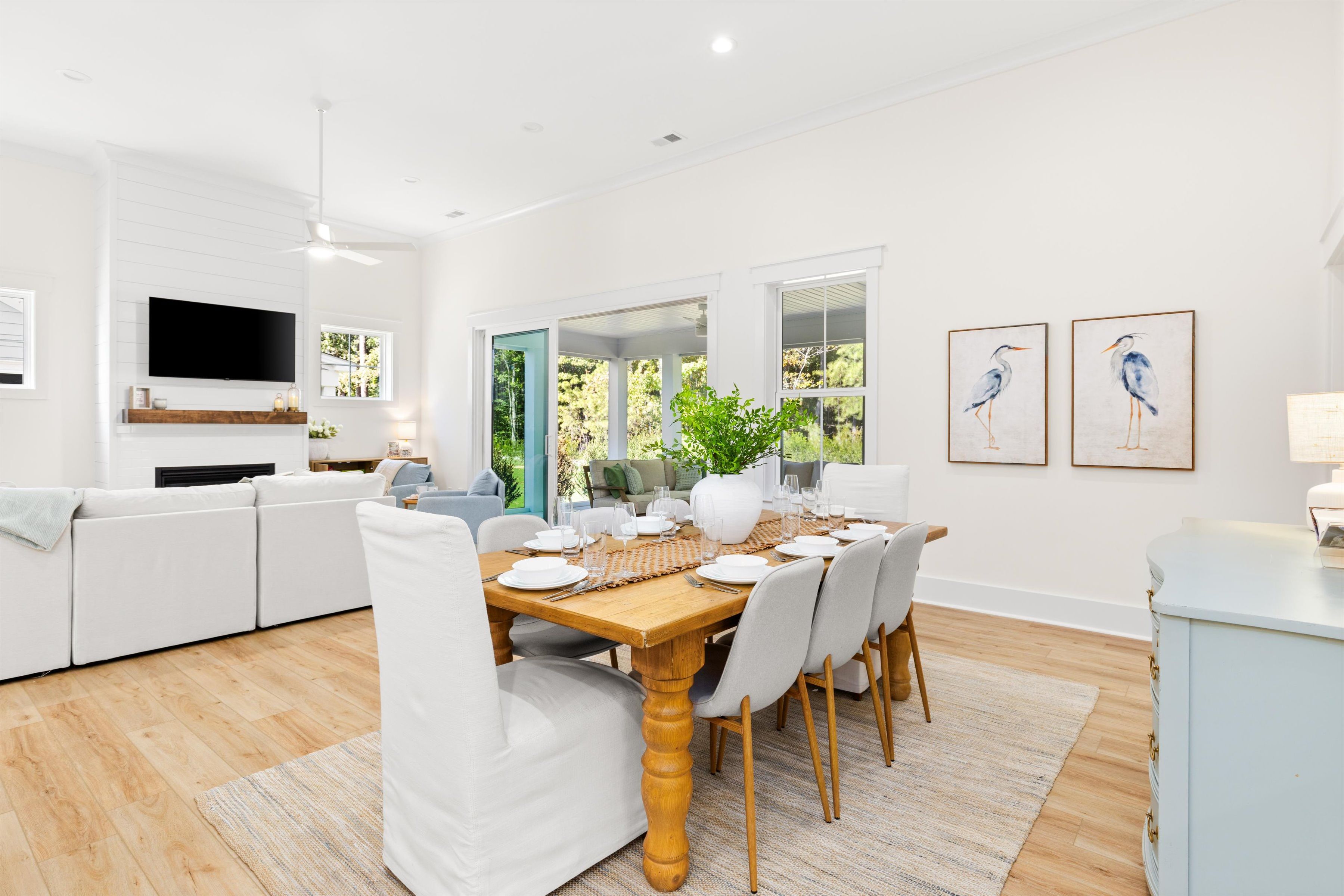Bright open-concept living and dining with vaulted ceilings and garden views