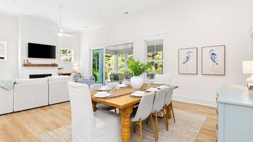 Bright open-concept living and dining with vaulted ceilings and garden views