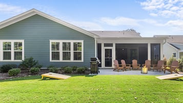 Sunny backyard with covered patio, fire pit, grill & lawn games