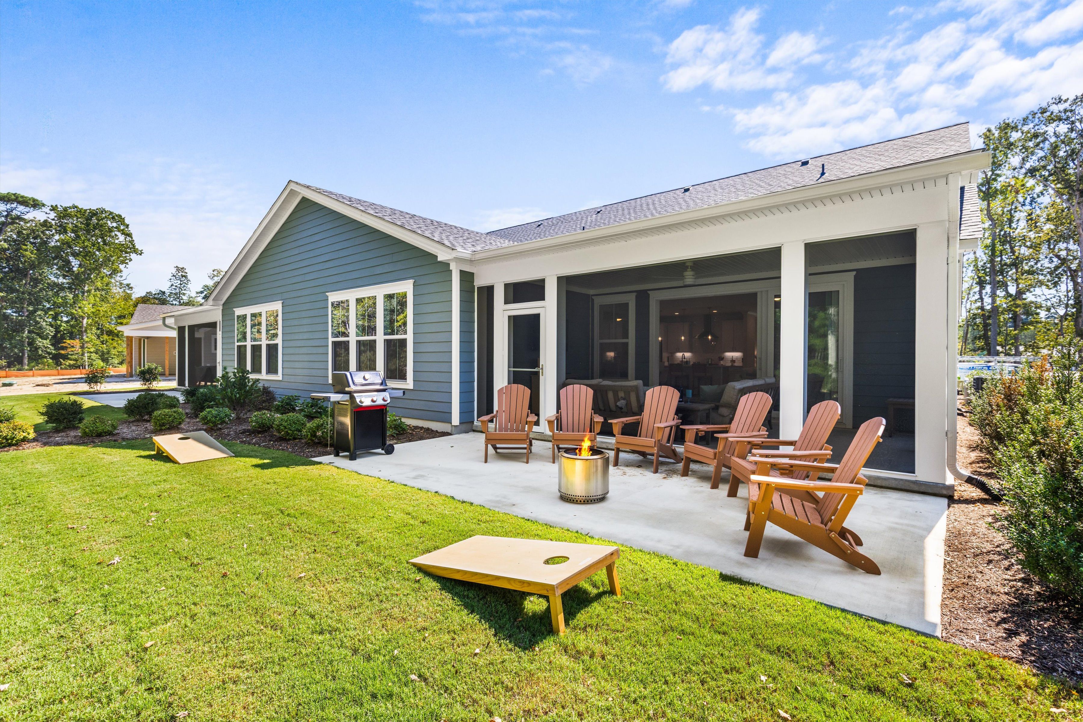Spacious backyard patio with fire pit, grill, and screened porch