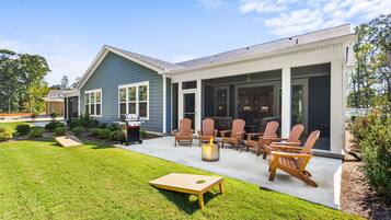 Spacious backyard patio with fire pit, grill, and screened porch