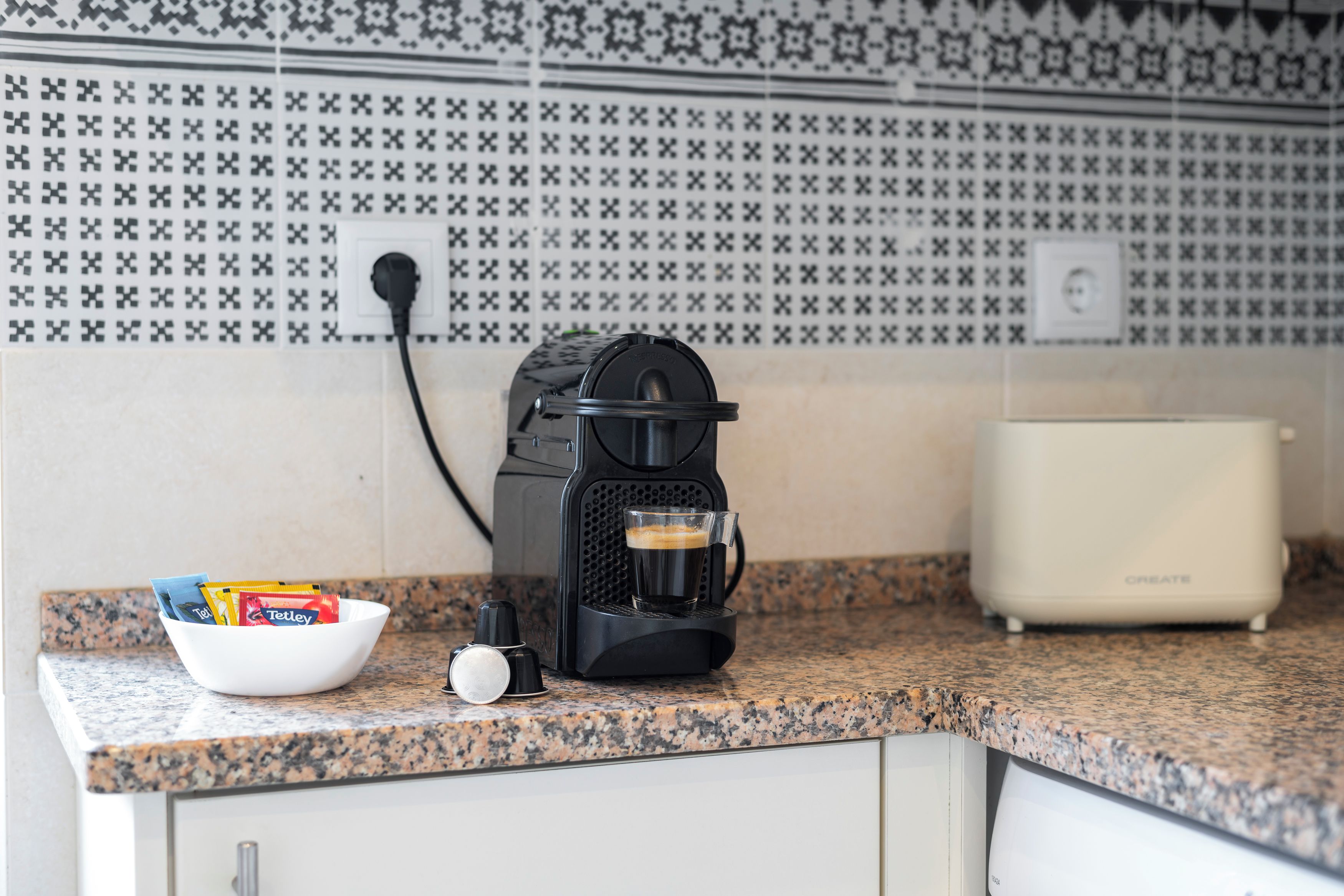 Une cuisine équipée d’une machine à café, d’un bol de collations et d’un grille-pain.