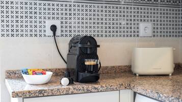 Une cuisine équipée d’une machine à café, d’un bol de collations et d’un grille-pain.