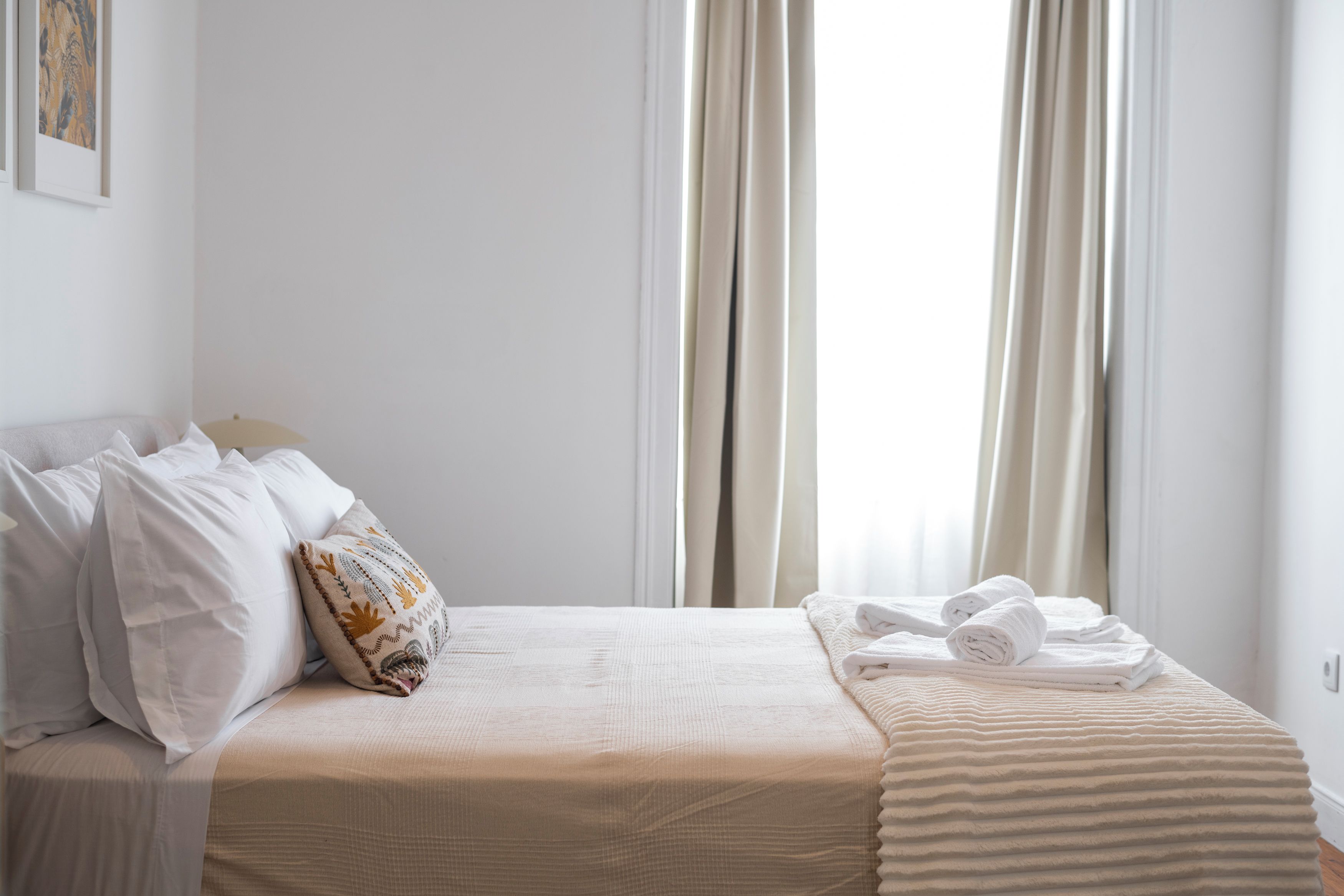 Une chambre d’hôtel avec un lit, des oreillers, une couverture et des serviettes.