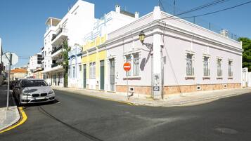 A street with buildings, a car, and a no entry sign.