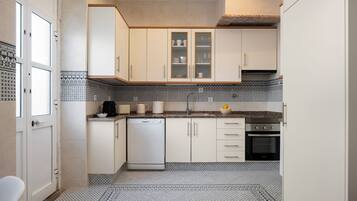Bright full kitchen with stylish tilework and built-in appliances
