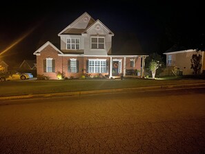 Ein zweistöckiges Haus mit Veranda, Garage und Auffahrt.