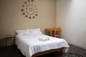 A single bed with white bedding, a wooden chair, and a small table. - Oaxacan house with a terrace (Oaxaca de Juárez)
