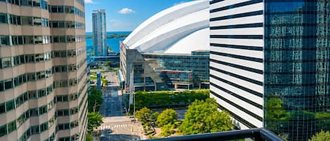 Un paisaje urbano con edificios modernos, una estructura blanca curva y vistas a la calle.