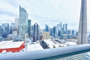 A cityscape with modern skyscrapers, a prominent tower, and a red building with a white roof. - The Modern Suites - Downtown Toronto (Toronto)