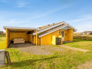 A single-story yellow building with a covered outdoor seating area and a small attached garage. - "Aarthi" - 300m from the sea by Interhome (Harboøre)