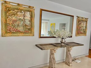 Een galerijwand met ingelijste kunstwerken en een spiegel in het midden.