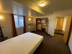 A hotel room with a bed, a wardrobe, a mirror, and a window. - Spacious 4-bedroom house in peaceful Salt Lake City with private patio (Salt Lake City)