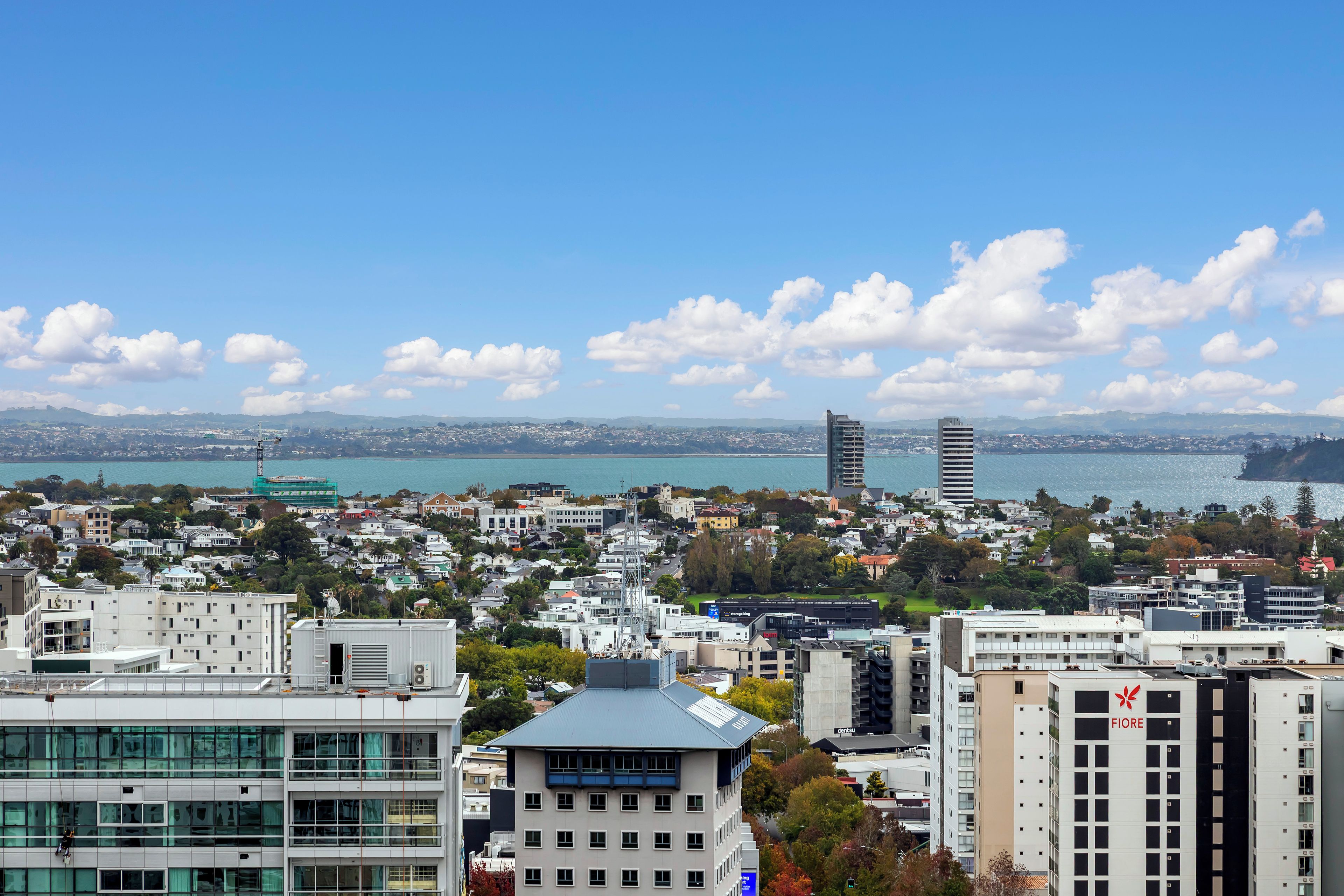 A cityscape with buildings, a body of water, and a clear sky.