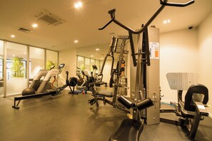 A gym with various exercise equipment, including treadmills and weight machines, and a mirrored wall. - Top Floor Loft • 2BR/2BA • Sky Tower & Sea Views (Auckland central)