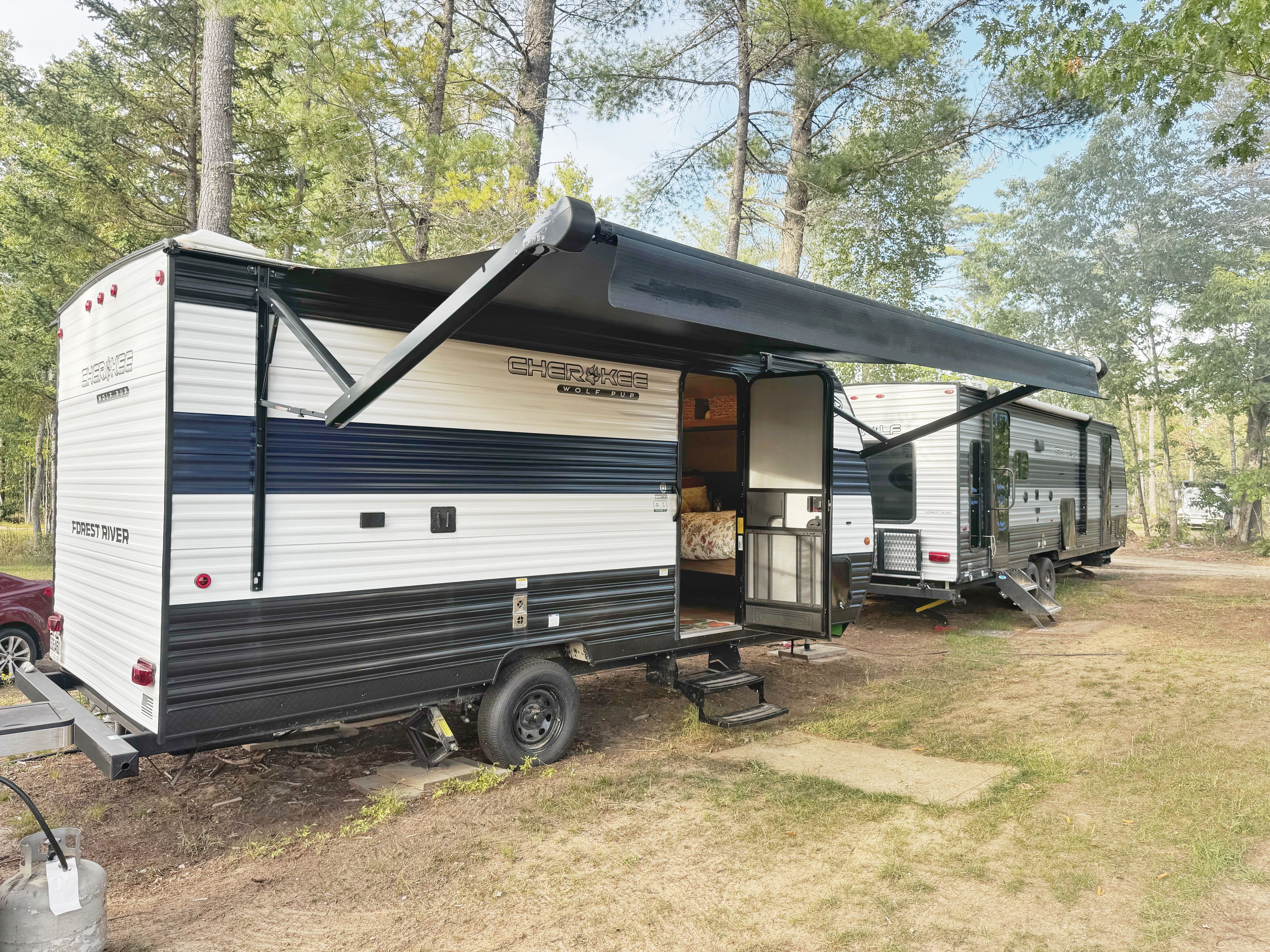 Een stacaravan met een overdekte veranda en een kleine aanbouw.