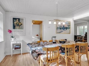 A dining area with a round table, chairs, a floral tablecloth, and a painting on the wall. - "Terese" - 200m to the fjord by Interhome (Farsø)