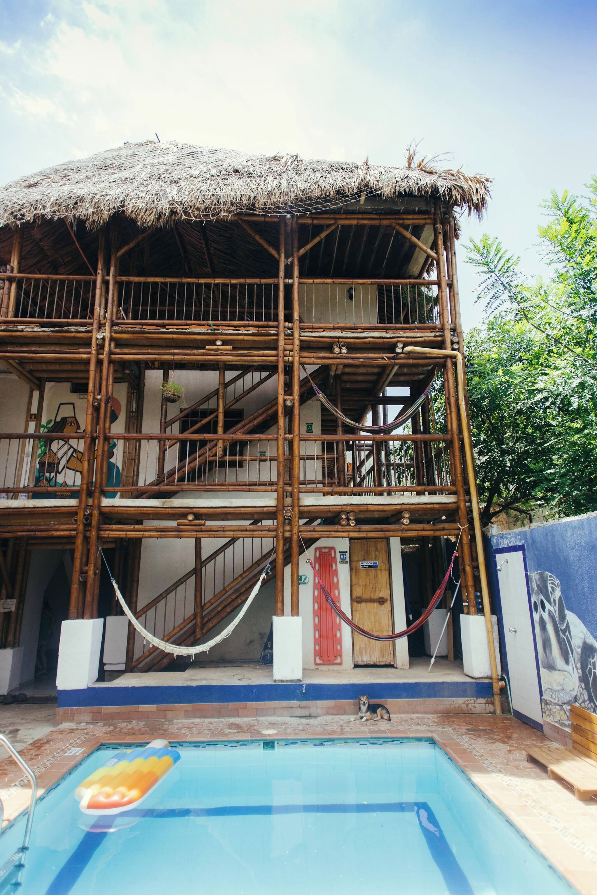 A two-story building with a thatched roof and bamboo scaffolding.