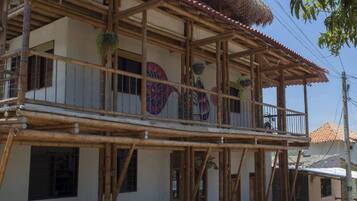 A two-story building with a balcony, wooden beams, and a thatched roof.