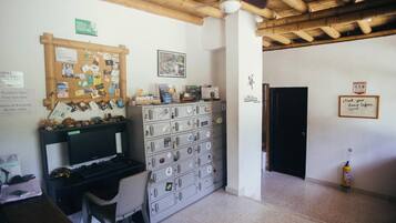 A reception area with a computer desk, a bulletin board, and a filing cabinet.