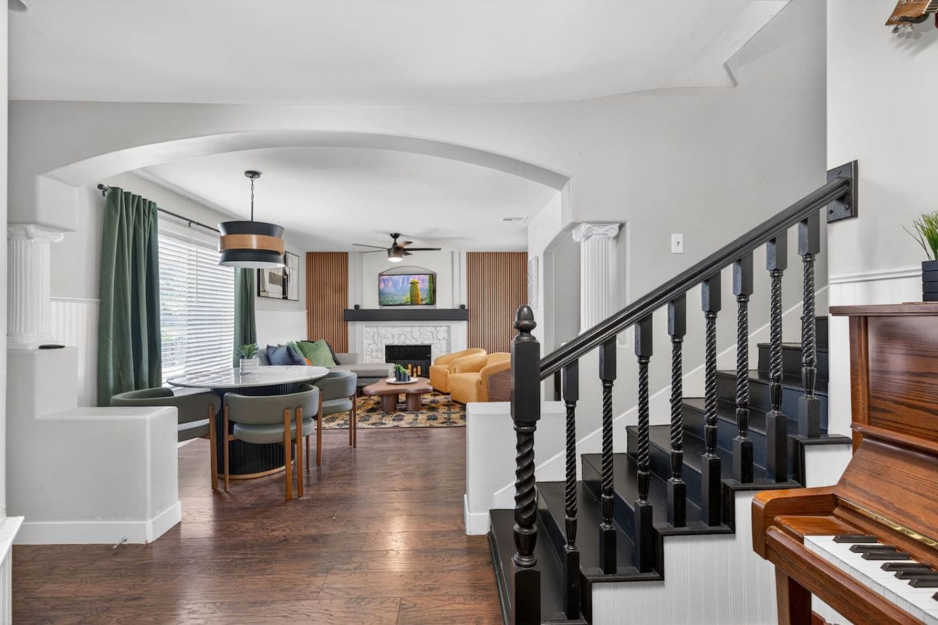 A modern interior with a staircase, dining area, and living room.