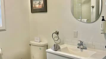 Ein Badezimmer mit Toilette, Waschbecken und Spiegel.