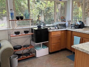 Eine kompakte Küche mit Herd, Toaster und Blick auf Grünflächen.