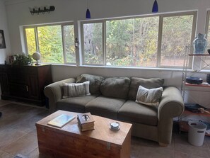 Ein Wohnzimmer mit einer Couch, einem Holztisch und einem Bücherregal.