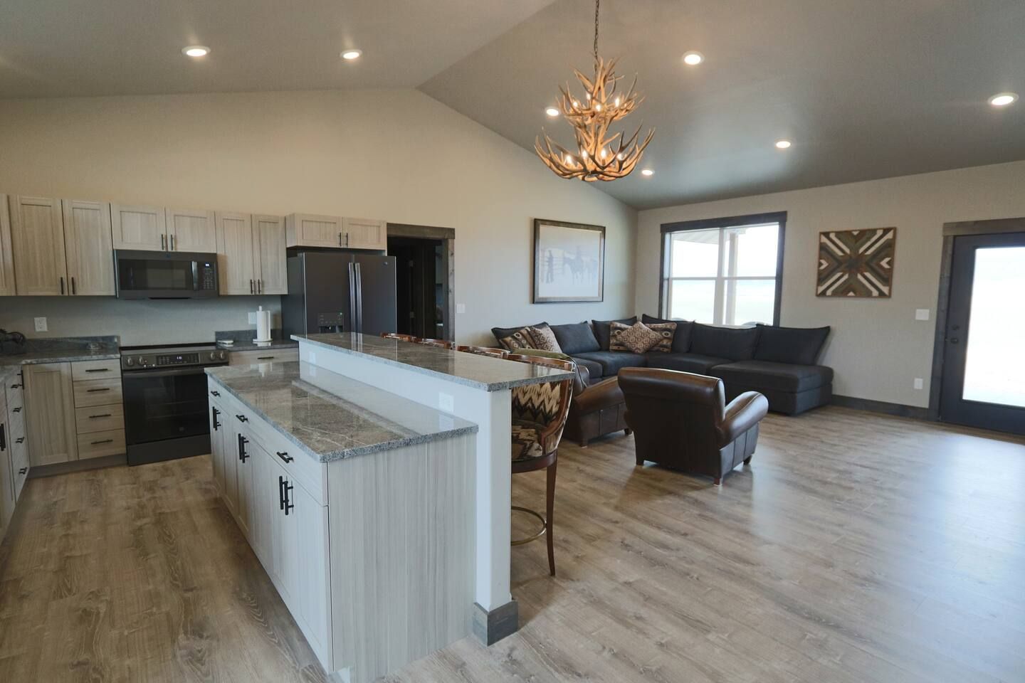 A spacious kitchen with a large island, modern appliances, and a dining area with a sofa and chairs.