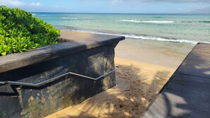 A concrete staircase leading to a sandy beach with ocean waves in the background. - Exceptional Family 2-bed/2 bath AC Pool & Garden View on Oceanfront Property (Lahaina)
