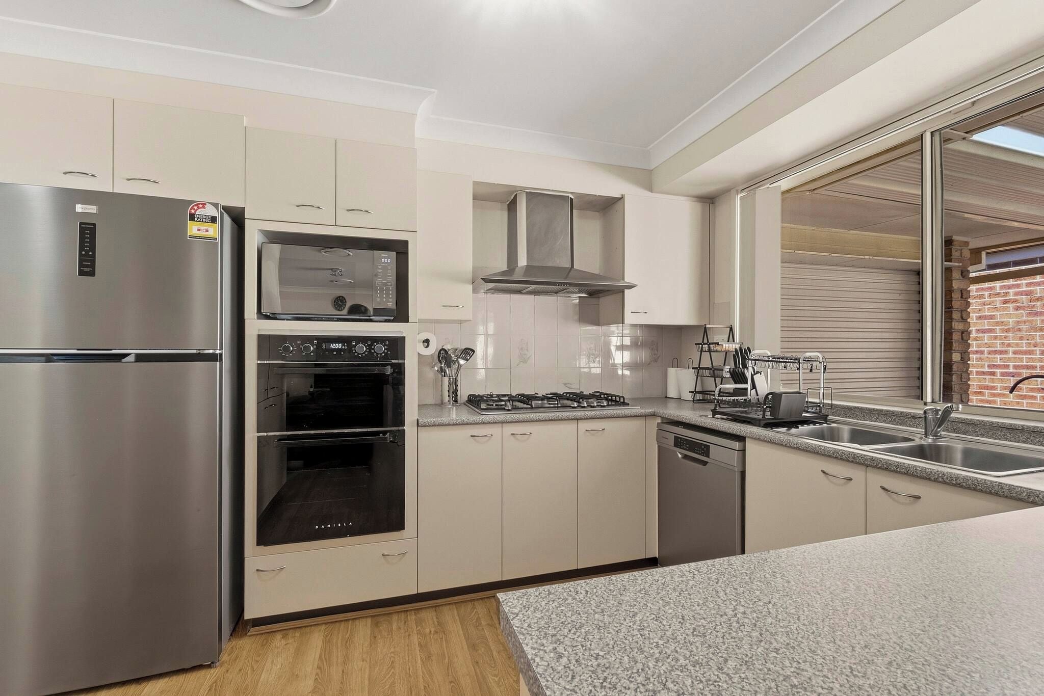 A modern kitchen with stainless steel appliances, a built-in oven, and a dishwasher.