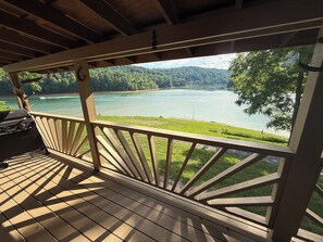 Eine Holzterrasse mit Blick auf einen See und Wald.
