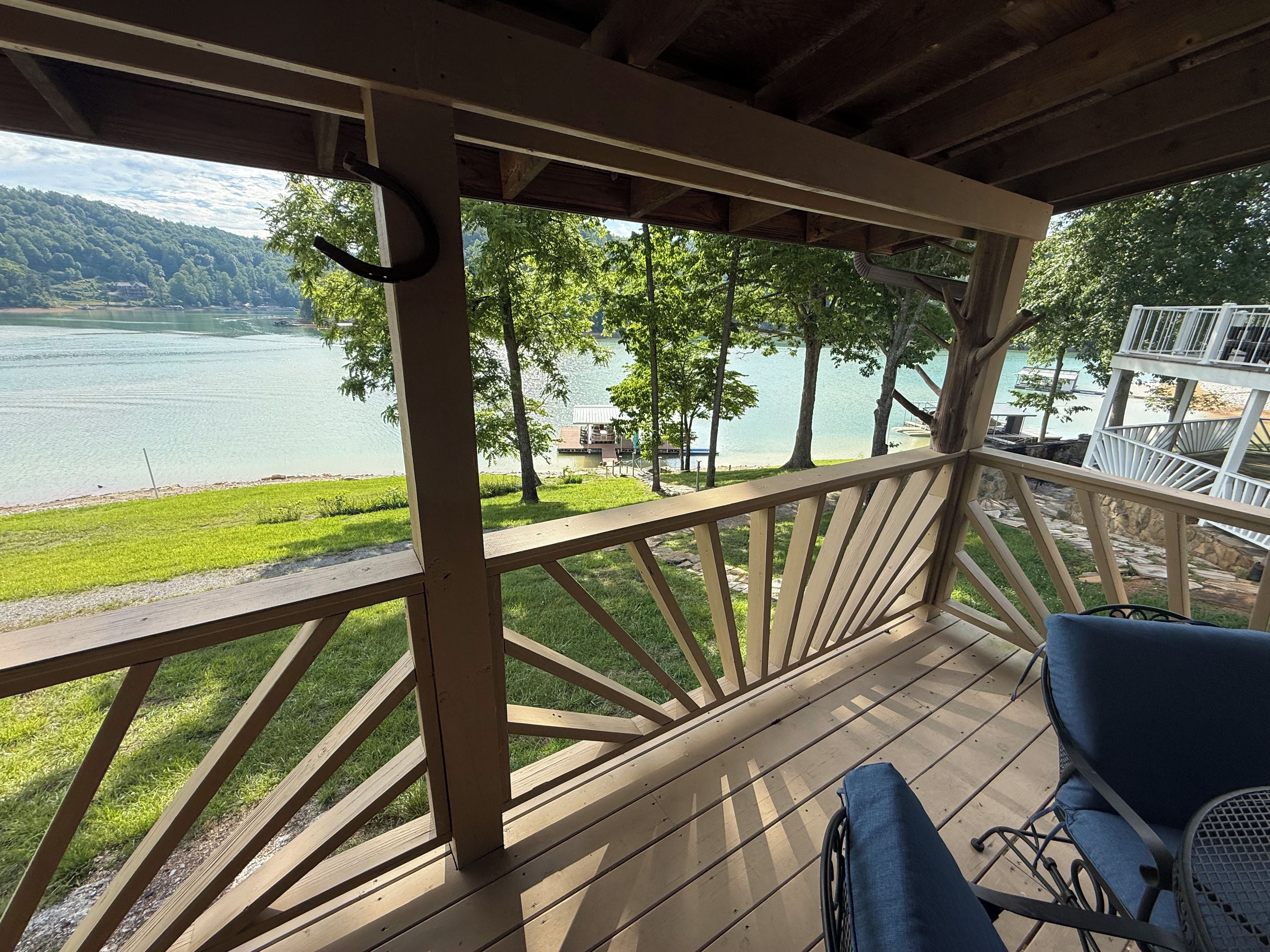 Une terrasse en bois offrant une vue sur un lac et des montagnes.