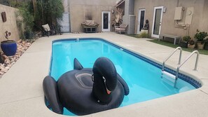 Ein Swimmingpool mit einem schwarzen Schwimmreifen in Form eines Schwans.