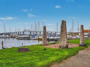 A marina with boats docked, a grassy area with stone structures, and a bridge in the background. - "Leefke" - 200m from the sea by Interhome (Rudkøbing)