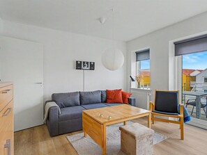 A modern living room with a grey sofa, a wooden coffee table, and a black chair. - "Leefke" - 200m from the sea by Interhome (Rudkøbing)