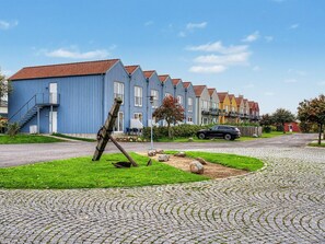 A row of colorful houses with a cobblestone pathway and a grassy area with a wooden sculpture. - "Leefke" - 200m from the sea by Interhome (Rudkøbing)