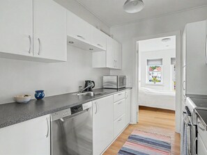 A modern kitchen with white cabinetry, a built-in dishwasher, and a microwave. - "Leefke" - 200m from the sea by Interhome (Rudkøbing)