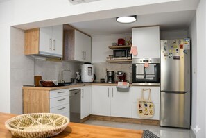 A compact kitchen with white cabinets, a stainless steel refrigerator, and a microwave. - OCEANIVES LUXURY VILA IN PALIO KAVALA ME KΗΠΟ (KAVALA)