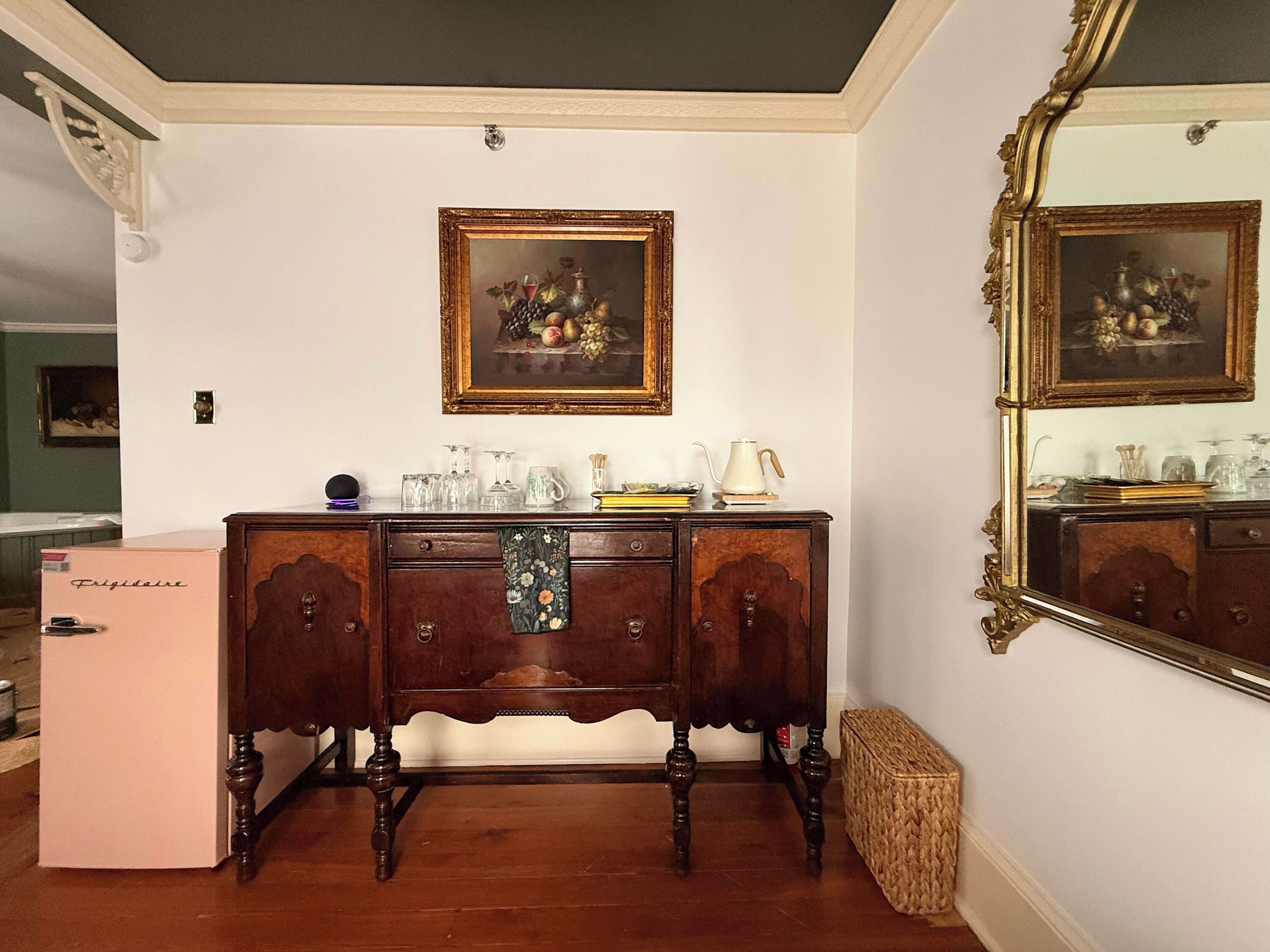 Une pièce comprenant une commode en bois, un miroir et un réfrigérateur.