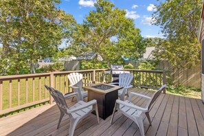 A deck with a grill, a fire pit, and four Adirondack chairs. - Family Friendly Beach House with linens and AC - Sleeps 8 (Dennis)