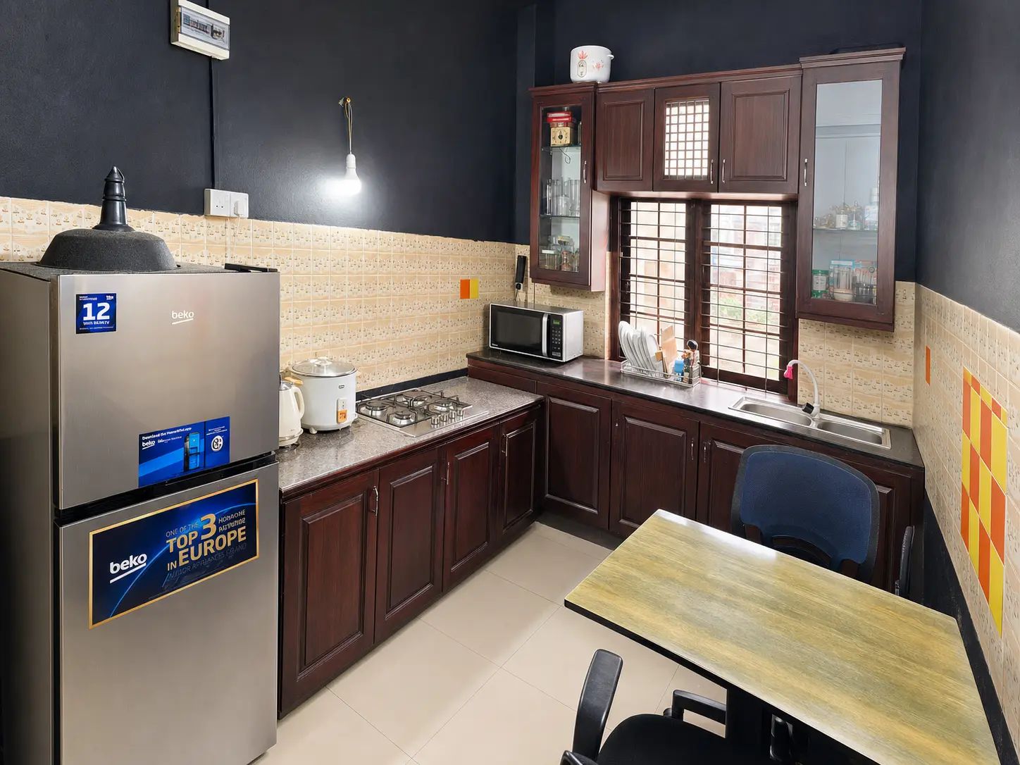 A compact kitchen with a refrigerator, microwave, stove, and cabinets.