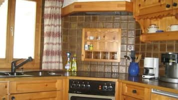 Une cuisine avec des meubles de rangement en bois, une étagère intégrée, une machine à café et un lave-vaisselle.