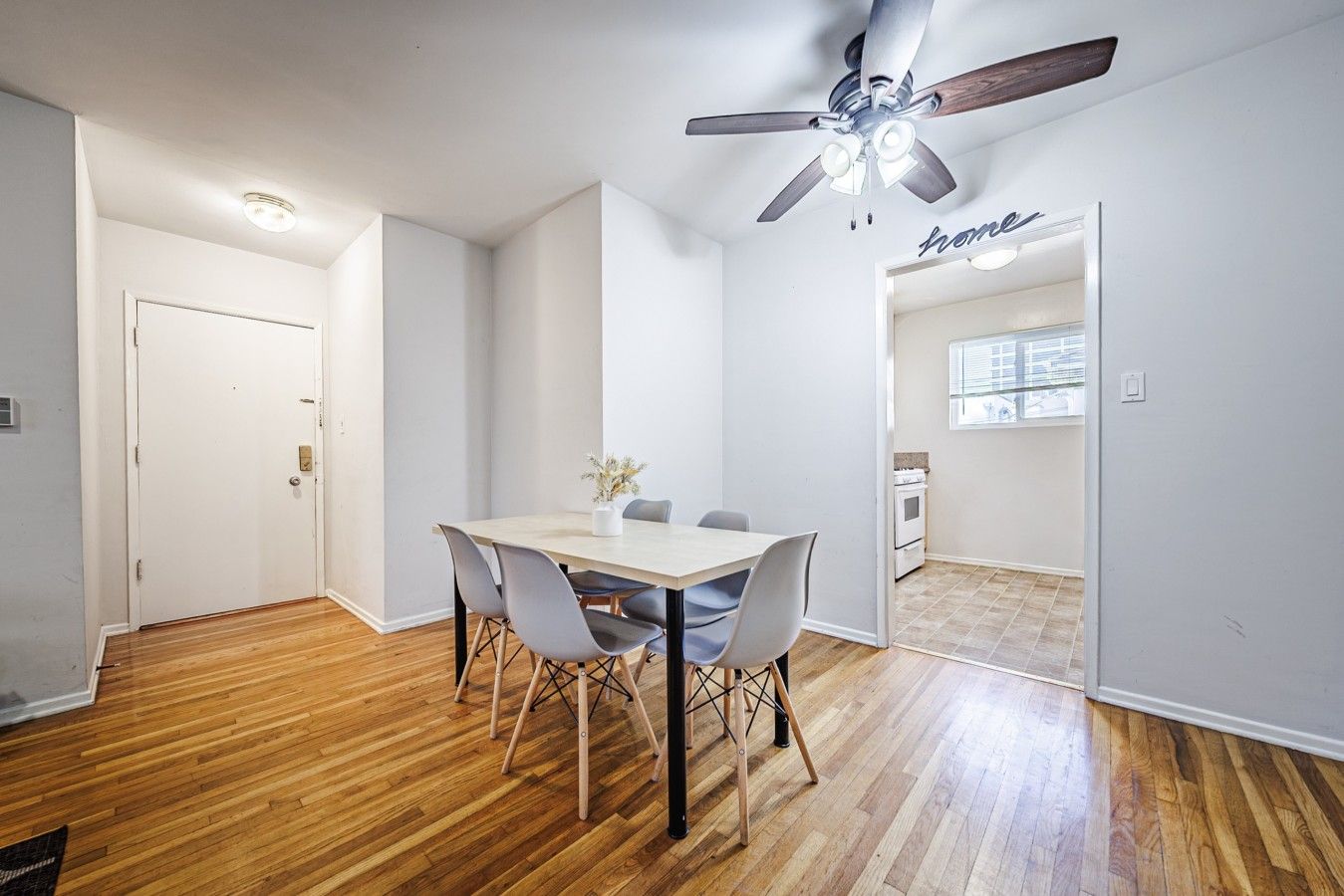 Uma área de refeições com mesa, cadeiras e ventilador de teto.