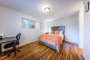 Quarto com cama, escrivaninha e cadeira.