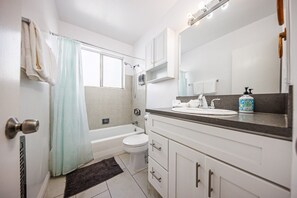 A bathroom with a bathtub, toilet, and sink. - Beverly Hills 1BR Sleeps 4, Parking, Near Cedars (Beverly Hills)