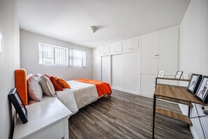 A bedroom with a bed, a desk, and a wardrobe. - Beverly Hills 1BR Sleeps 4, Parking, Near Cedars (Beverly Hills)